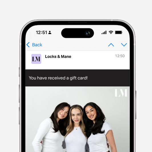 Phone screen showing a gift card notification from 'Locks & Mane' with three women on the screen.